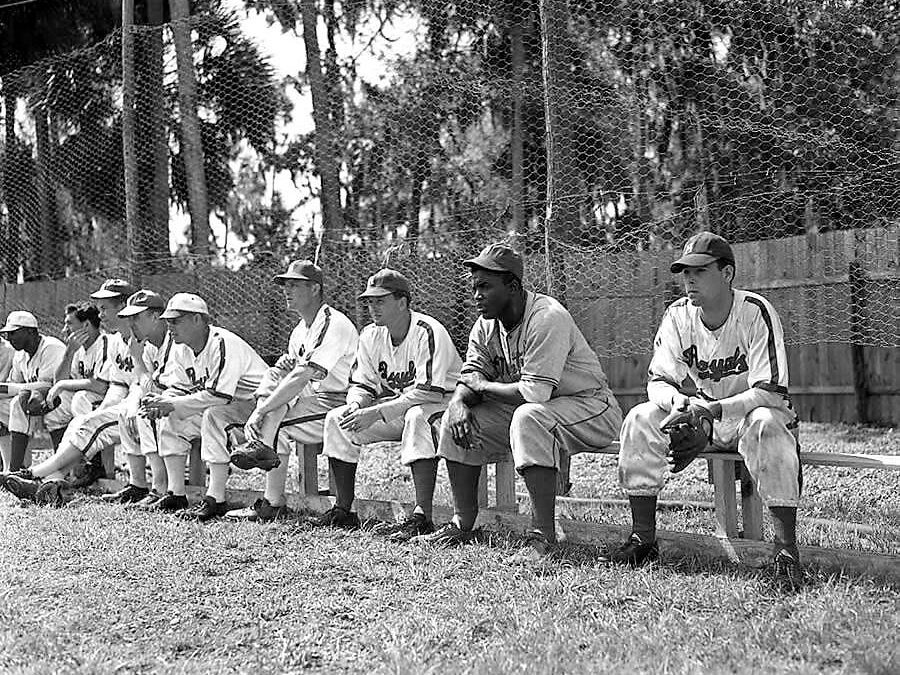 Jackie Robinson finds himself a seat on Montreal’s bench as he joins the Royals for the first time in an exhibition game against their major league affiliate, the Brooklyn Dodgers.